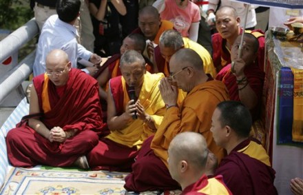 Exiled Tibetan spiritual leader the Dalai Lama, right,  prays for the victims and comforts survivors of Typhoon Morakot, at the destroyed village of Shiao Lin, in southern Taiwan, Monday, Aug. 31, 2009. (AP Photo/Wally Santana)