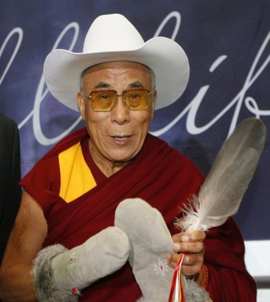 His Holiness the Dalai Lama, wears a traditional white cowboy hat, native leather mitts and a traditional native eagle feather he received as welcoming gifts at the Calgary airport in Calgary, Alberta, 30 September 2009. The White Hat ceremony is a Calgary tradition reserved for dignitaries and is a symbol of Calgary's hospitality, and the eagle feather is a gift by the natives to only the highest dignitaries. REUTERS/Pool (CANADA RELIGION IMAGES OF THE DAY)
