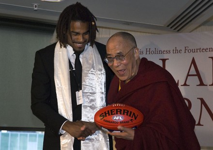 His Holiness the Dalai Lama is presented with an Australian Rules football by Harry O'brien in