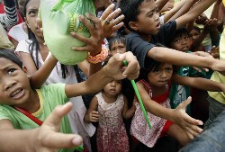 Residents line up for relief supplies at an evacuation center in Iligan City, Philippines on December 19, 2011. (AP/Bullit Marquez